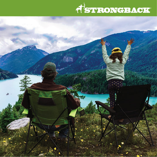 People sitting in Elite Chairs by lake Small child is standing on top of one with hand in the air.